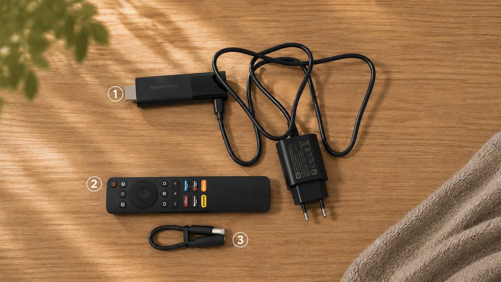 Комплект ТВ-приставки Xiaomi на деревянном столе: под номером 1 — приставка с блоком питания, под номером 2 — пульт дистанционного управления, под номером 3 — короткий соединительный кабель.